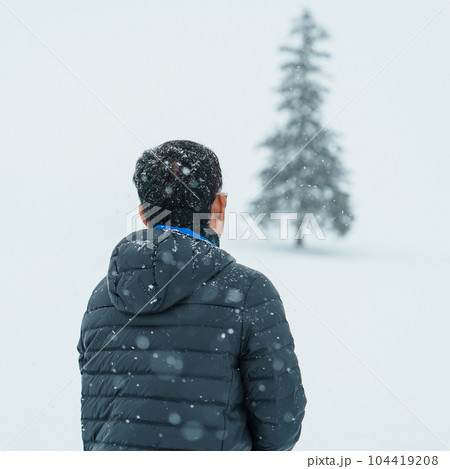 man tourist Visiting in Biei, Traveler in Sweater sightseeing Christmas tree with Snow in winter season. landmark and popular for attractions in Hokkaido, Japan. Travel and Vacation concept 104419208