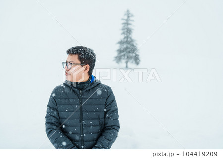 man tourist Visiting in Biei, Traveler in Sweater sightseeing Christmas tree with Snow in winter season. landmark and popular for attractions in Hokkaido, Japan. Travel and Vacation concept 104419209