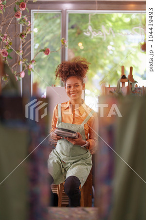 Beautiful American African artist woman painting in art studio at the university classroom Beautiful American African artist woman painting in art studio at the university classroom 104419493