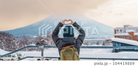 Woman tourist Visiting in Niseko, Traveler in Sweater sightseeing Yotei Mountain with Snow in winter season. landmark and popular for attractions in Hokkaido, Japan. Travel and Vacation concept 104419889