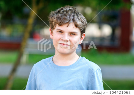 Portrait of positive preteen school kid boy. Beautiful happy child looking at the camera. Schoolboy smiling. 104421062