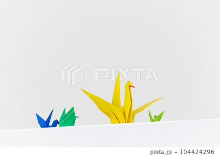 Colorful paper cranes on a white background. low angle Colorful paper cranes on a white background. low angle 104424296