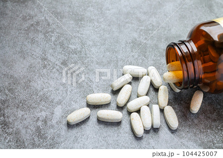 Medical pills spilling open drug bottle Medical pills spilling open drug bottle 104425007