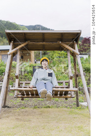 キャンプ場にある木製ブランコに乗る小学生子供 104425654