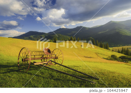 Ukraine, Ivano Frankivsk region, Verkhovyna district, Dzembronya village, Old farm machine in rural landscape in Carpathian Mountains Ukraine, Ivano Frankivsk region, Verkhovyna district, Dzembronya village, Old farm machine in rural landscape in Carpathian Mountains 104425947