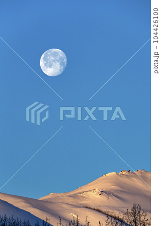USA, Idaho, Sun Valley, Full moon over snow-covered hills 104426100