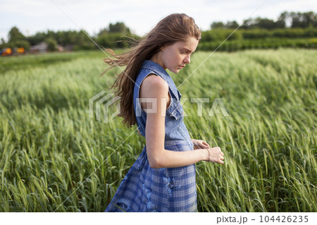 Portrait of woman standing in field Portrait of woman standing in field 104426235
