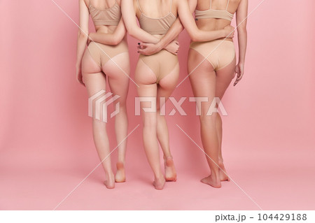 Cropped image of female body, buttocks and legs against pink studio background. models in underwear. Depilation, epilation, anti-cellulite massage Cropped image of female body, buttocks and legs against pink studio background. models in underwear. Depilation, epilation, anti-cellulite massage 104429188