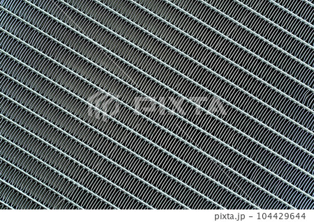 Texture of a honeycomb of an automotive aluminum car cooling radiator, close-up. Texture of a honeycomb of an automotive aluminum car cooling radiator, close-up. 104429644