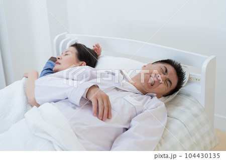 ベッドで寝苦しそうな高齢者夫婦(睡眠不足・不眠) ベッドで寝苦しそうな高齢者夫婦(睡眠不足・不眠) 104430135