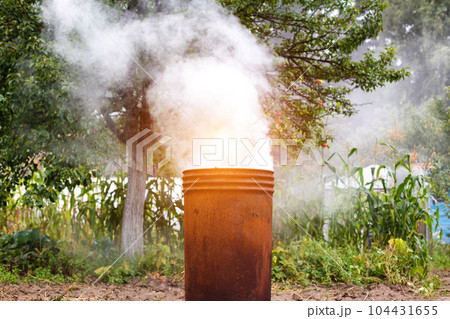 Burning dry grass and garbage in the country in the fall in an iron barrel. Penalty and fire hazard if weed is burned incorrectly. A lot of smoke 104431655