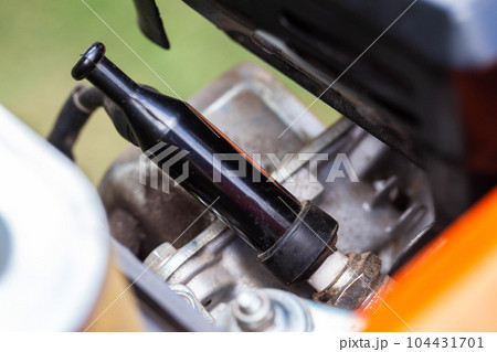 Spark plug in the engine cylinder of a walk-behind tractor. Maintenance of the ignition system. Industry 104431701