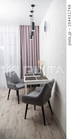 Modern interior of a dining table in the kitchen and comfortable chairs 104431749
