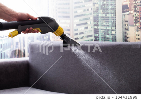 Applying a special cleaning solution to clean stains and dirt on upholstery of upholstered furniture. The first stage of dry cleaning. Copy space for text Applying a special cleaning solution to clean stains and dirt on upholstery of upholstered furniture. The first stage of dry cleaning. Copy space for text 104431999