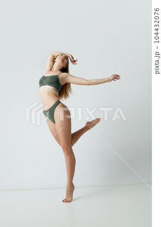 Full-length portrait of young beautiful woman with blonde hair, slim fit body posing in underwear against grey studio background Full-length portrait of young beautiful woman with blonde hair, slim fit body posing in underwear against grey studio background 104432076