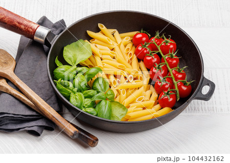A vibrant representation of the Italian flag made with pasta, basil, and tomatoes 104432162