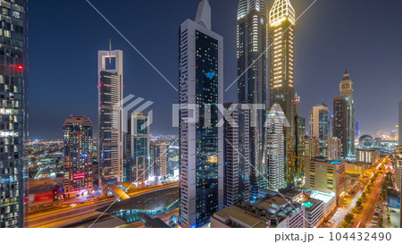 Aerial view of Dubai International Financial District with many skyscrapers day to night timelapse. Aerial view of Dubai International Financial District with many skyscrapers day to night timelapse. 104432490