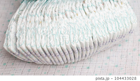 Many stacks of baby soft and comfortable diapers on a white background, close-up Many stacks of baby soft and comfortable diapers on a white background, close-up 104433028