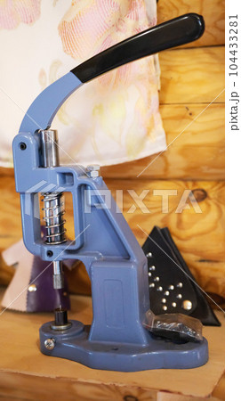 A metal device for riveting buttons on clothes. Close-up 104433281