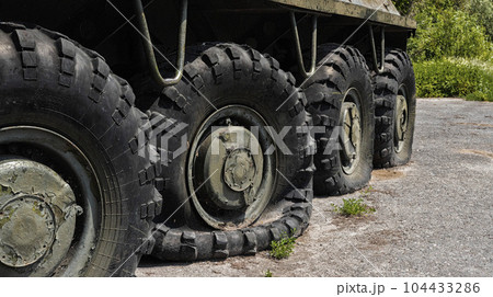 Flat and punctured wheels of armored personnel carriers during a military battle. Military conflict and weapons. 104433286