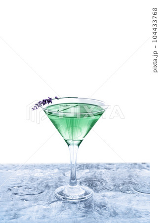 Modern green transparent cocktail adorned with lavender standing on ice bar. Isolated white background. Great design with copy space. Summer drinks concept. 104433768