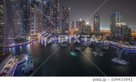 Panorama showing luxury yacht bay in the city aerial night timelapse in Dubai marina 104433941