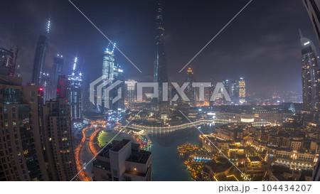 Skyscrapers rising above Dubai downtown all night timelapse surrounded by modern buildings aerial top view 104434207