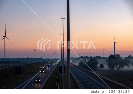 Aerial view of sunrise over a highway with traffic on a light misty morning in Belgium, Europe 104435137