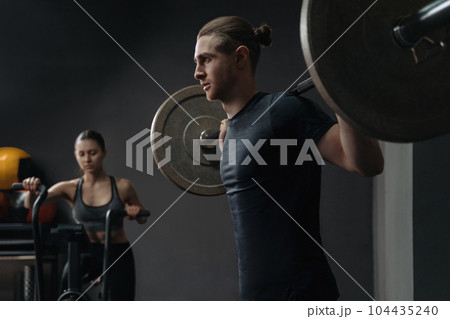 Caucasian young sporty couple working out together at gym Caucasian young sporty couple working out together at gym 104435240