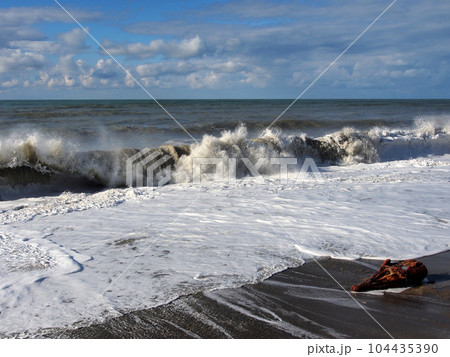 Cold stormy sea waves rush onto the shore covered with large pebbles. Landscape photography, a variety of landscapes, travel.	 104435390
