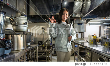 厨房を確認する女性スタッフ　OKサイン 104436486