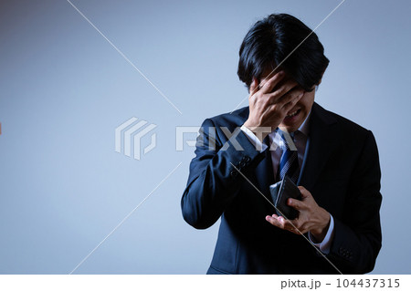 財布を見て悩む男性 財布を見て悩む男性 104437315