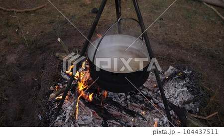 cooking on a campfire in the forest cooking on a campfire in the forest 104437511