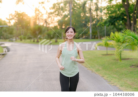 Fit Asian young woman jogging in park smiling happy running and enjoying a healthy outdoor lifestyle. Female jogger. Fitness runner girl in public park. healthy lifestyle and wellness being concept Fit Asian young woman jogging in park smiling happy running and enjoying a healthy outdoor lifestyle. Female jogger. Fitness runner girl in public park. healthy lifestyle and wellness being concept 104438006