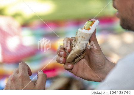 man is holding a burrito in his hand 104438746