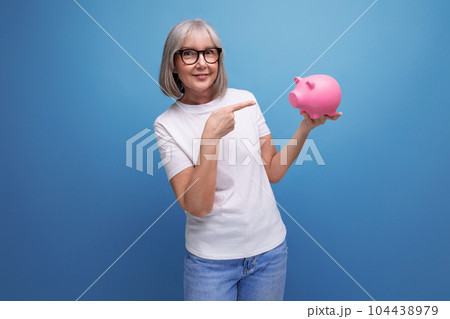 grandmother with gray hair thinks where to invest her savings on a studio background with copy space 104438979