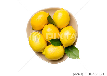 Fresh cutted lemon and whole lemons over round plate isolated on white background. Food and drink ingredients preparing. healthy eating theme top view with copy space Fresh cutted lemon and whole lemons over round plate isolated on white background. Food and drink ingredients preparing. healthy eating theme top view with copy space 104439321