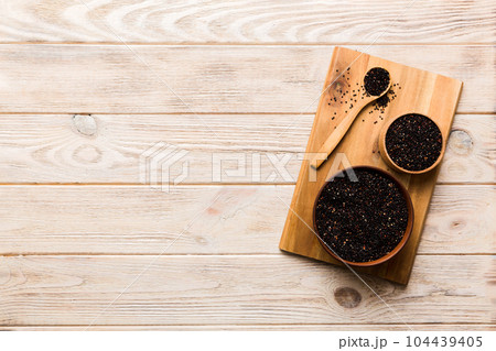 quinoa seeds in bowl and spoon on colored background. Healthy kinwa in small bowl. Healthy superfood quinoa seeds in bowl and spoon on colored background. Healthy kinwa in small bowl. Healthy superfood 104439405