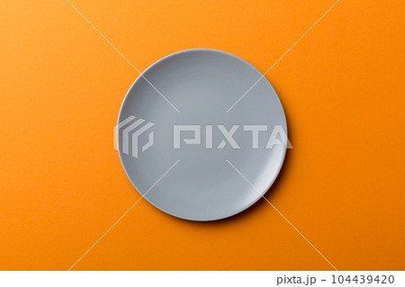 Top view of isolated of colored background empty round gray plate for food. Empty dish with space for your design 104439420