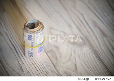 new Ukrainian hryvnia. 500 hryvnia on wooden table bind with rubber tape to tube. money background and wealth concept 104439752