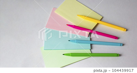 Colored felt-tip pens and multi-colored stickers on a light background Colored felt-tip pens and multi-colored stickers on a light background 104439917