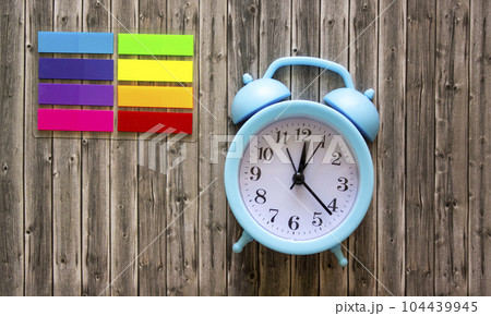Clock and color stickers on wooden background Clock and color stickers on wooden background 104439945