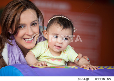 Young mother playing with her baby daughter. Early stimulation for toddlers concept. 104440109