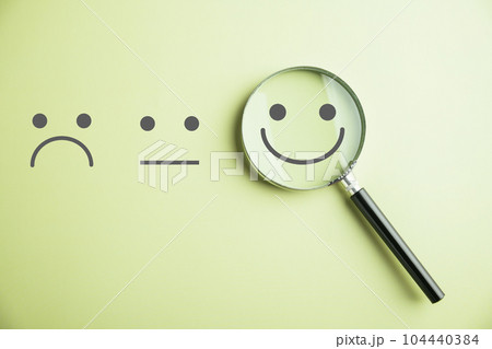 Magnifying glass reveals smiley face, finding happiness amid sadness. Customer satisfaction and evaluation after service survey. Magnification, satisfaction, reputation, corporate, customer Magnifying glass reveals smiley face, finding happiness amid sadness. Customer satisfaction and evaluation after service survey. Magnification, satisfaction, reputation, corporate, customer 104440384