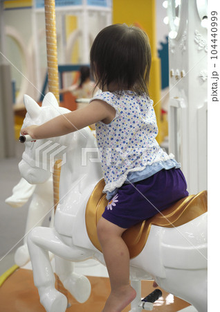 メリーゴーランドに乗った赤ちゃんの後ろ姿の写真素材 [104440999] - PIXTA