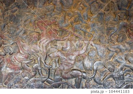 Hindu mythology battle scenes masterfully chiseled into the stone walls of an ancient Khmer temple, epitomizing the craftmanship of ancient artists. Hindu mythology battle scenes masterfully chiseled into the stone walls of an ancient Khmer temple, epitomizing the craftmanship of ancient artists. 104441183