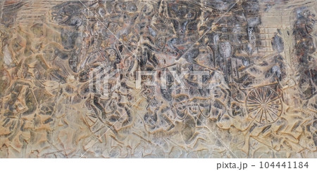 A captivating display of ancient art, featuring detailed carvings of Hindu mythology's battle scenes on the walls of a historic Khmer temple. A captivating display of ancient art, featuring detailed carvings of Hindu mythology's battle scenes on the walls of a historic Khmer temple. 104441184