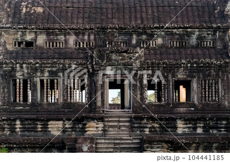 The facade of an ancient stone Khmer structure, the ancient architecture of Cambodia. The facade of an ancient stone Khmer structure, the ancient architecture of Cambodia. 104441185