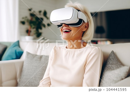 Senior mature female having fun with virtual reality glasses. Old woman using new headset goggles trends technology 104441595