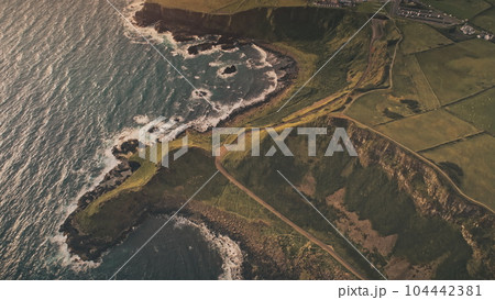 Top down sun rural lands aerial. Nobody nature landscape at ocean shore. Autumn fields, grass meadow 104442381